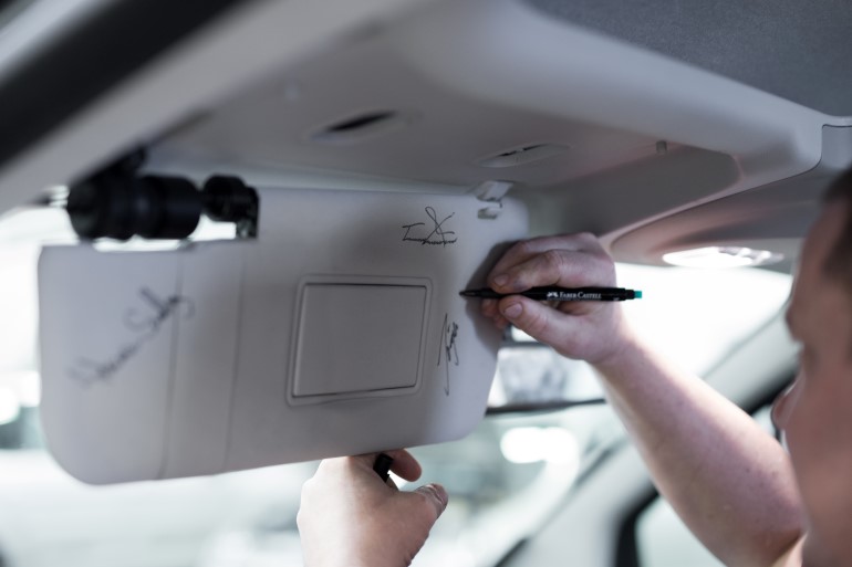 Vehicle adaptation technician Jörgen in the middle of jotting down his John Hancock on the sun visor of our customer's new car. 