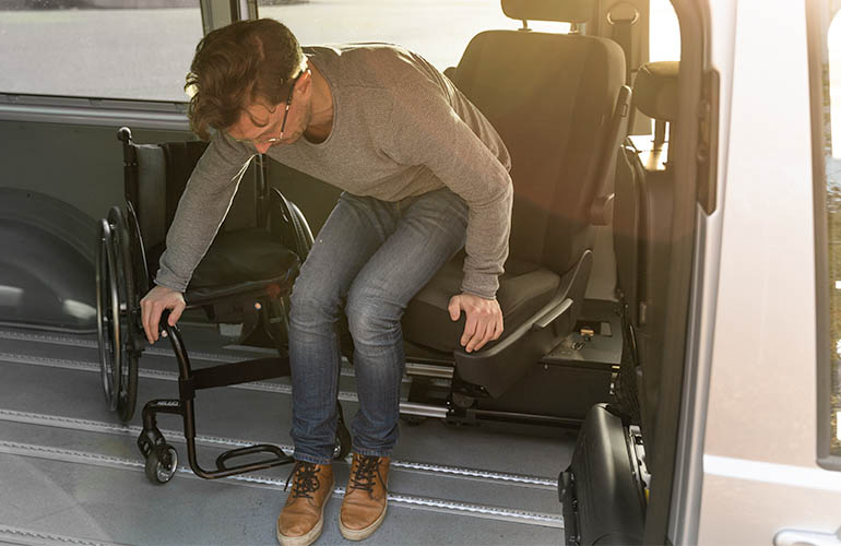 Top view of a person transferring from the driver's seat to a wheelchair using a Turny 6-Way. 