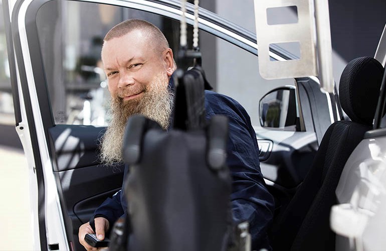 Man sitting in a Turny Evo seat lift swiveled out of a car