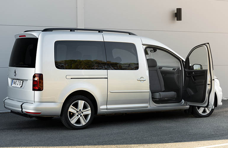 Vue complète d’une Volkswagen Caddy avec la portière passager avant ouverte. Le siège passager avant est tourné vers le spectateur.