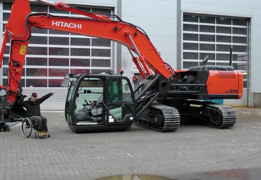 Person in wheelchair next to an accessible excavator