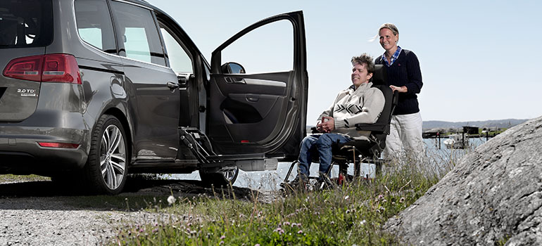 Woman pushing a man in a Carony wheelchair