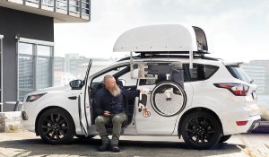 Man retreating his wheelchair from the top of a car with a chair topper