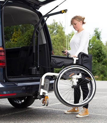 Woman retrieving a wheelchair from a car with a hoist