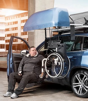 Man retrieving wheelchair from a roof top box