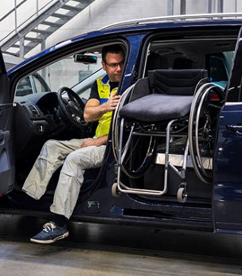 Man loading a wheelchair into the second row seat