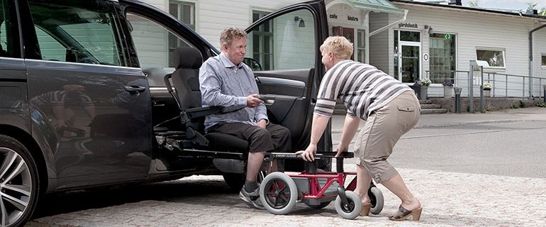 Woman assisting man getting into the car with a Carony Classic