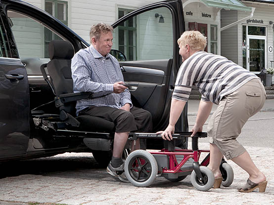 Woman assisting man getting into the car with a Carony Classic