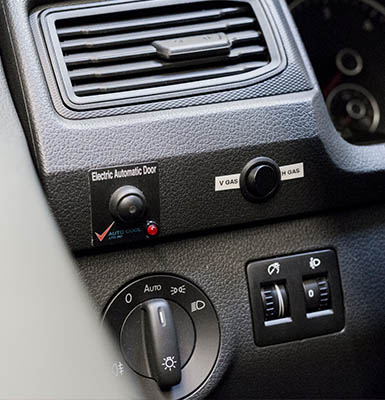 The dashboard of a car with retrofitted switches and buttons. 