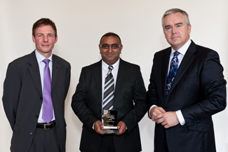 Autoadapt UK's Carl Birkin, Office Manager, and John Bhogal, UK Sales Director, with the Motability Operations Supplier Awards' host, BBC newsreader Huw Edwards.