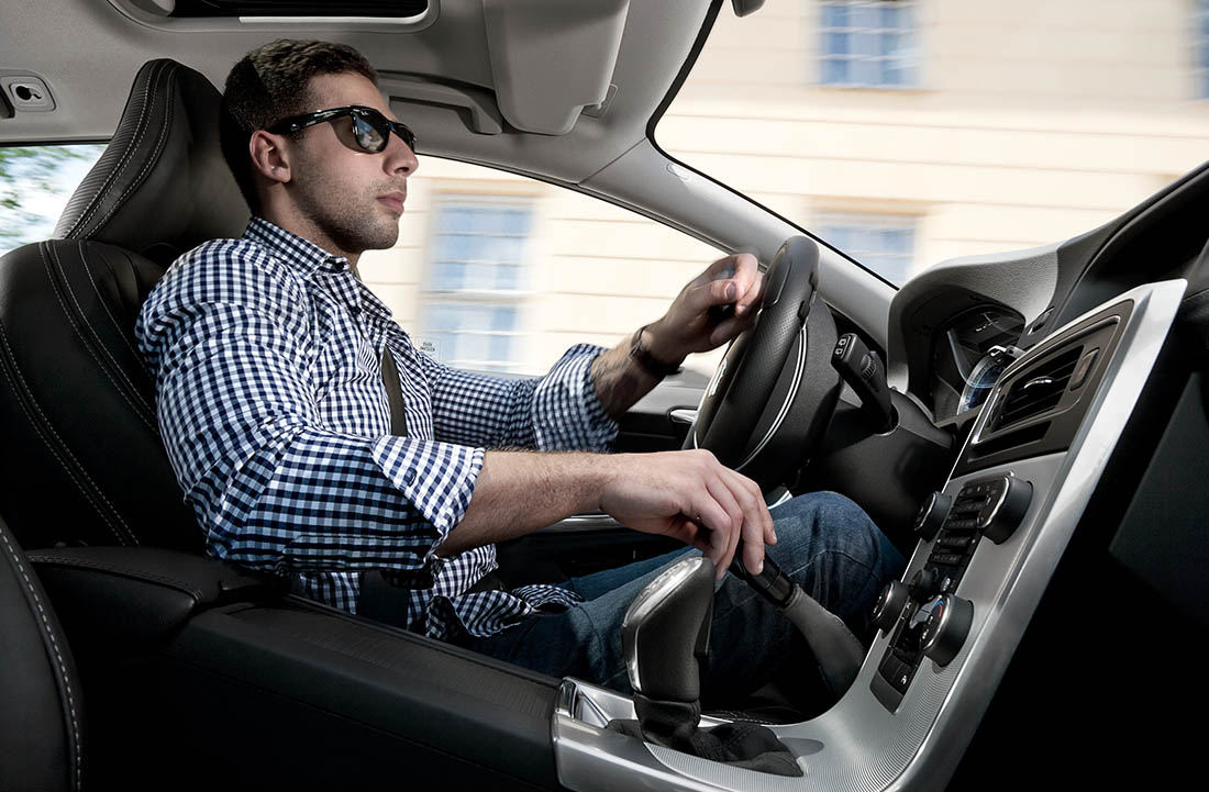 Mann, der ein Auto mit Handsteuerungen fährt