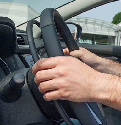 Close up of hands on steering wheel and gas ring