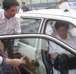 Mr Jian Guo, General Manager of Beijing Fengrunyongheng Mechanism Electron Equipment Co.,Ltd. (standing) and Deputy Director of Beijing Disabled People's Federation Mr Zhengming Lu (sitting in the car) tries out the Swedish swivel seat.