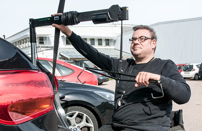 Mann im Rollstuhl, der einen Auto-Rollstuhlaufzug vorbereitet
