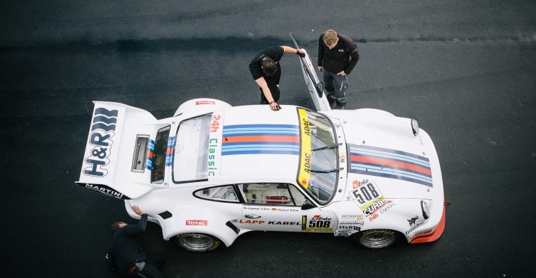 Deux hommes inspectant une voiture de course.