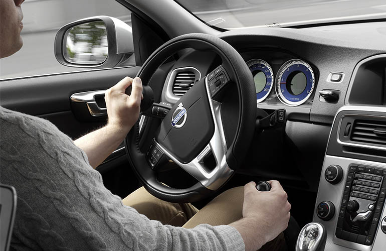 Close up of a hand holding a steering knob installed in a car