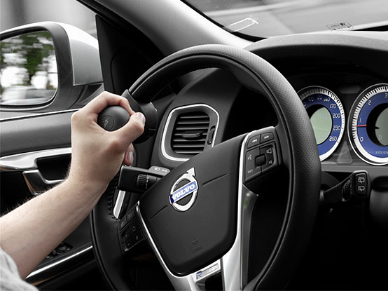 Close up of a hand holding a steering knob installed in a car