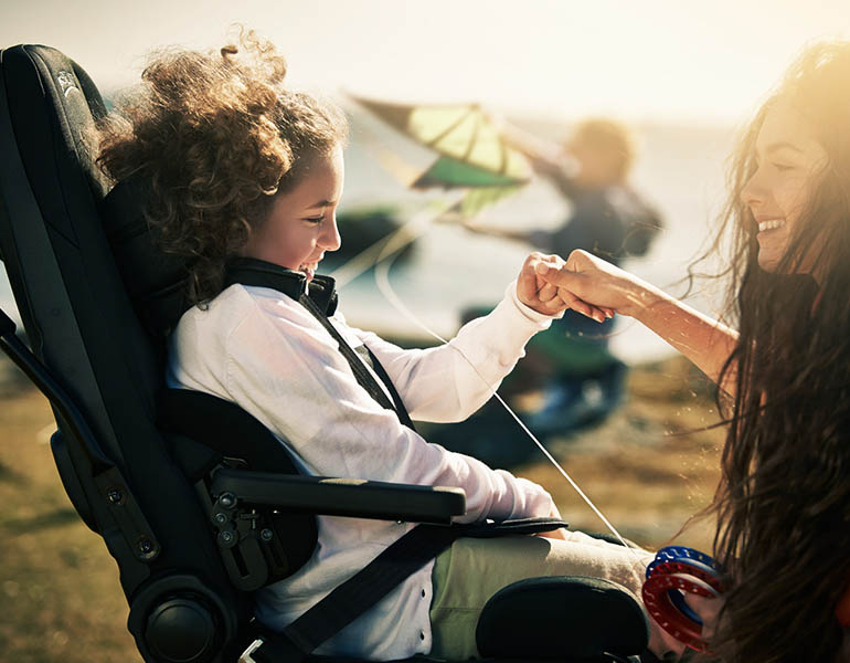 An older girl looking at a younger girl seated in a GS seat.