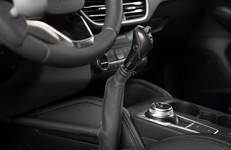 Picture 1: man driving a car with hand controls Picture 2: close up of two hand controls installed in a car