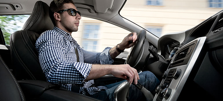 Homme conduisant une voiture avec commandes manuelles