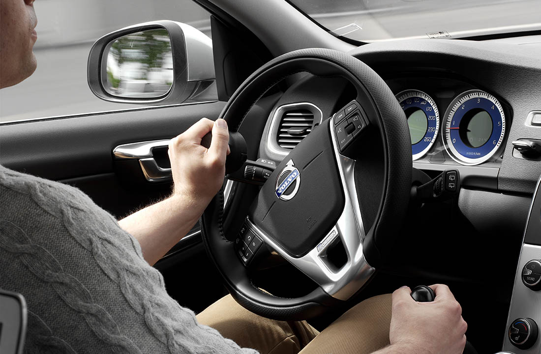 Man driving a car using hand controls