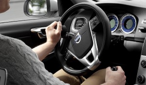 Man driving a car using hand controls