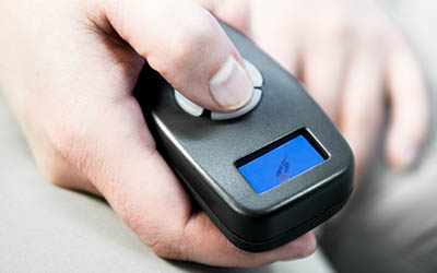 Zoom in of a hand pressing a button on a hand held control