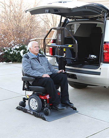 Mann steigt mit seinem Elektrorollstuhl in einen Joey Lift