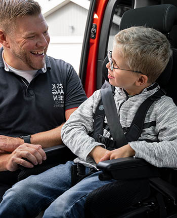 Man smiling at young boy inside a car