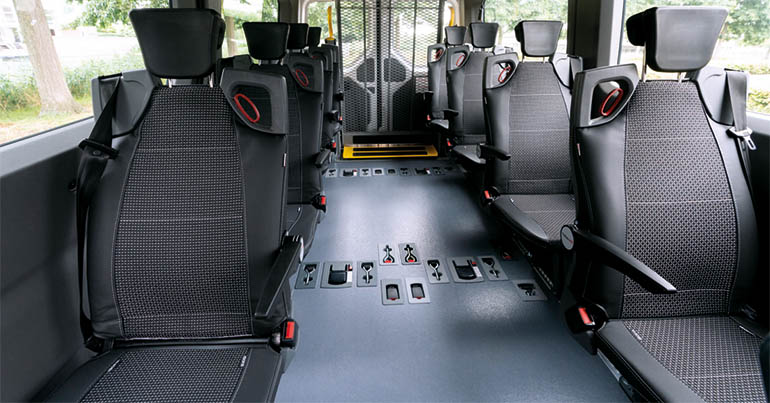 Vehicle with seats installed on each side of the aisle  and a lift on the rear end