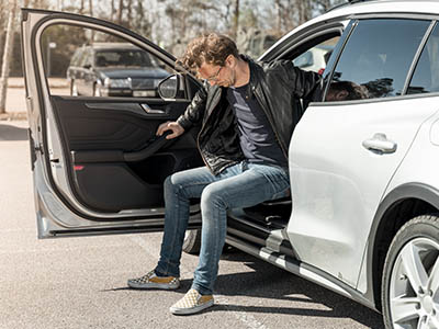 Man using the BraunAbility transfer board to assist in leaving the car.