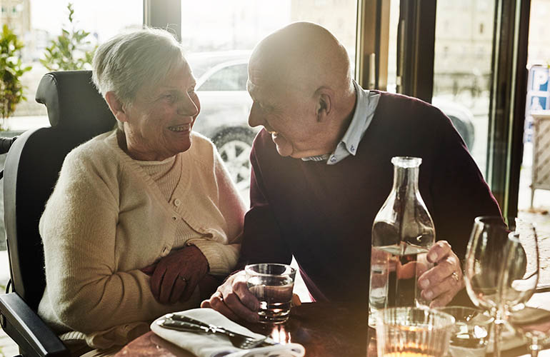 Woman in a Carony wheelchair and a man dining