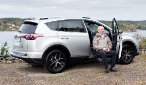 Man sitting on a swivel seat outside of a car