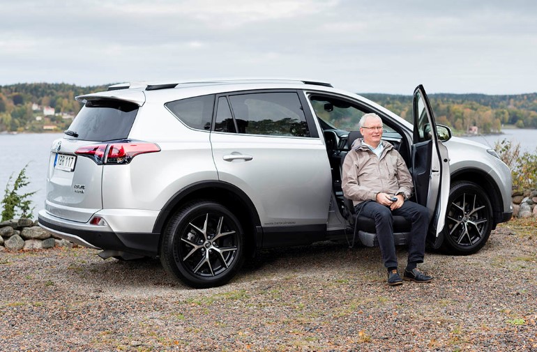 Man sitting on a swivel seat outside of a car