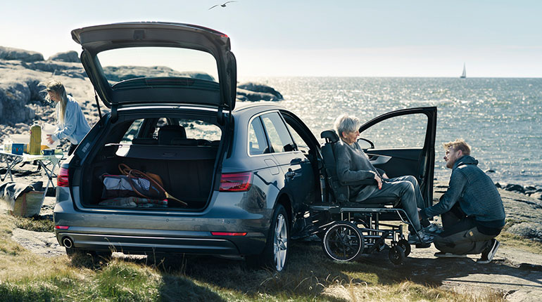 Young man assisting older woman to transfer into a car with the Carony.