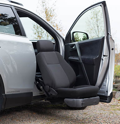 A seat lift with the car seat on the outside of the car.