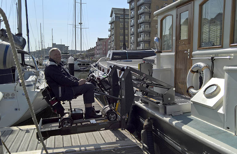 Einsteigen in ein Boot in einem Elektroroller leicht gemacht mit einem Rollstuhllift.