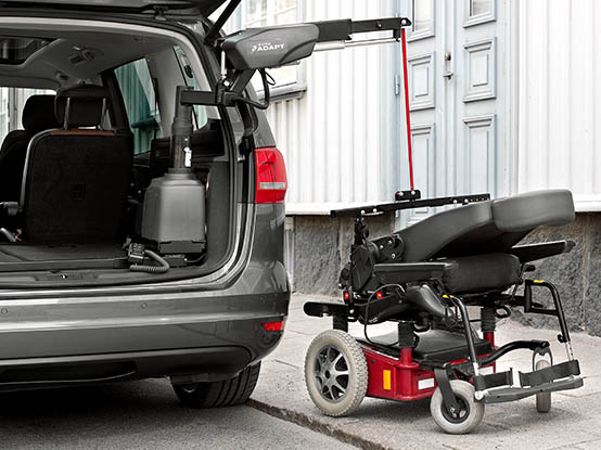 A powered wheelchair being lifted into a car with a Carolift 6900